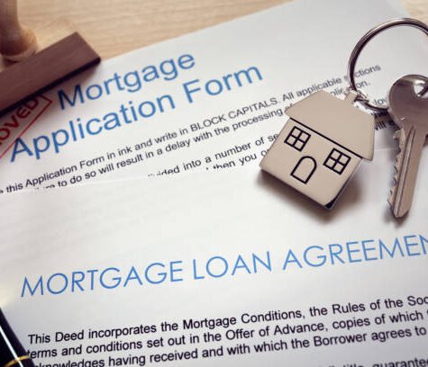 Mortgage loan agreement application with key on house shaped keyring Mortgage loan agreement application with key on house shaped keyring