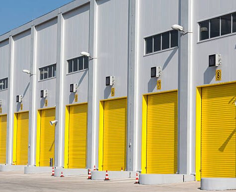 An industrial warehouse with eight large yellow drive-in doors for big trucks. An industrial warehouse with eight large yellow drive-in doors for big trucks.