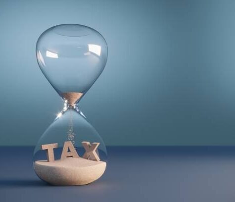 Flowing sand shaped of tax text inside the hourglass. (3d render) Flowing sand shaped of tax text inside the hourglass. (3d render)