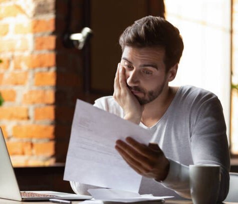 Confused frustrated young man reading letter in cafe, debt notification, bad financial report, money problem, money problem, upset student receiving bad news, unsuccessful exam or test results